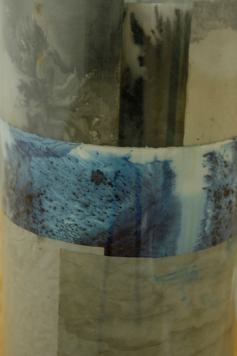 Detailes of one the sculptures, some layers of watercolor drawings are visible, blue, black and grey color from a packaging paper, is the palette of this one
