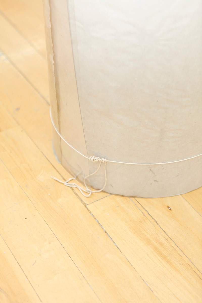 Detail of how the tube like sculpture containing drawings is touching the ground, and some some details of how a simple rope supports the polycarbonate sheets to mantain their form